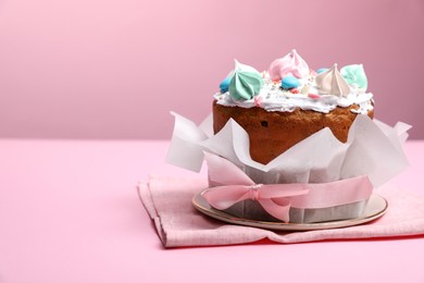 Photo of Traditional Easter cake with meringues on pink background, space for text