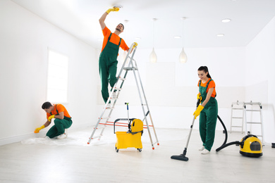 Photo of Teamprofessional janitors cleaning room after renovation