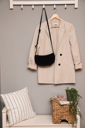 Bench and coat rack on grey wall in hallway. Interior element