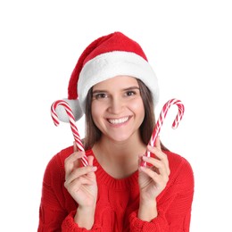Pretty woman in Santa hat and red sweater holding candy canes on white background
