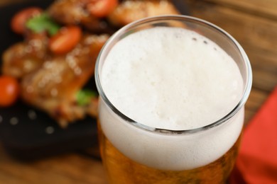 Glass of fresh beer on table, closeup view