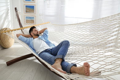 Photo of Young man relaxing in hammock at home