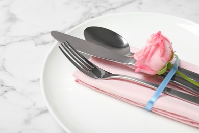 Photo of Beautiful table setting with cutlery, napkin and plate on marble background, closeup