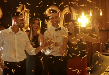 Young people celebrating New Year in club. Golden 2020 balloons on background