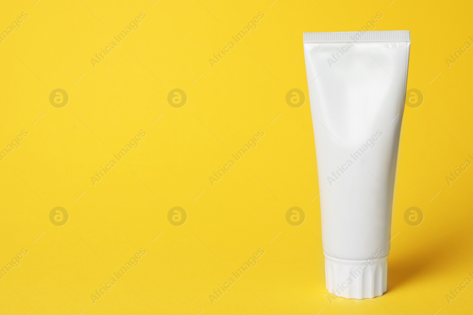 Photo of Blank tube of toothpaste on color background. Space for text