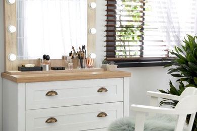 Photo of Dressing table with luxury cosmetics and accessories in room near window