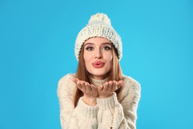 Young woman wearing Christmas sweater on blue background