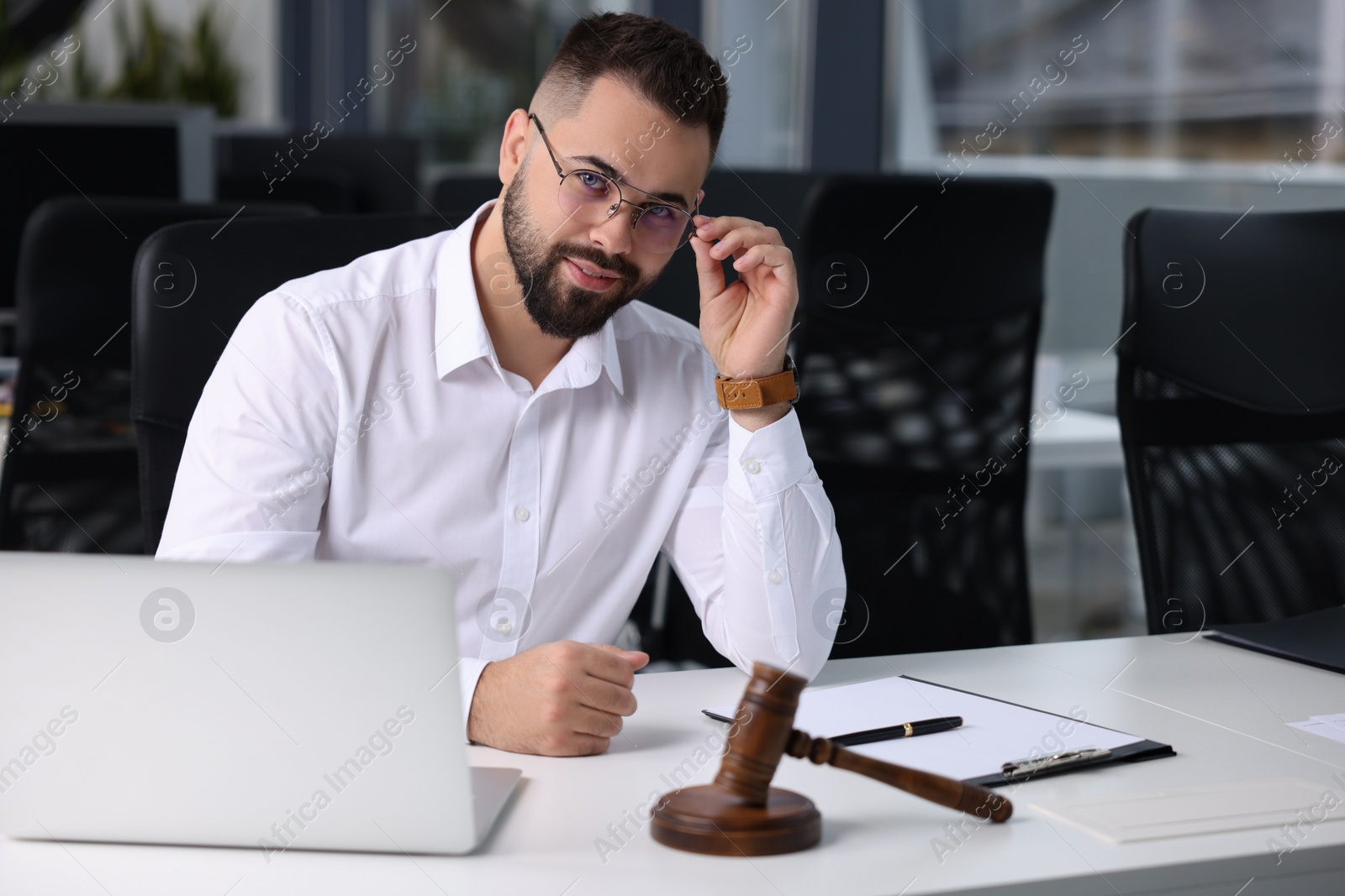 Photo of Portrait of serious lawyer at table in office