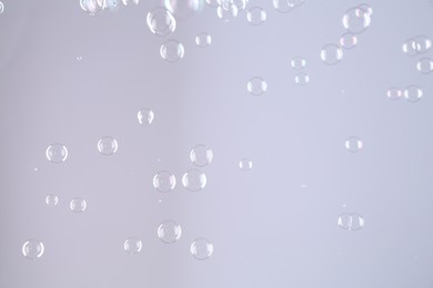 Photo of Beautiful transparent soap bubbles on grey background