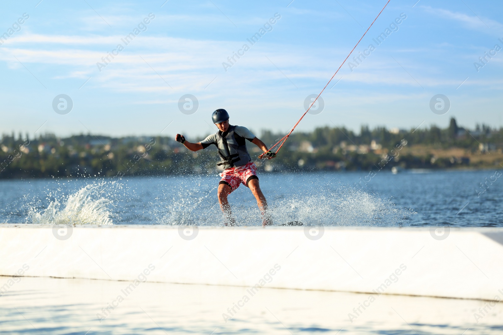 Photo of Teenage boy wakeboarding on river. Extreme water sport