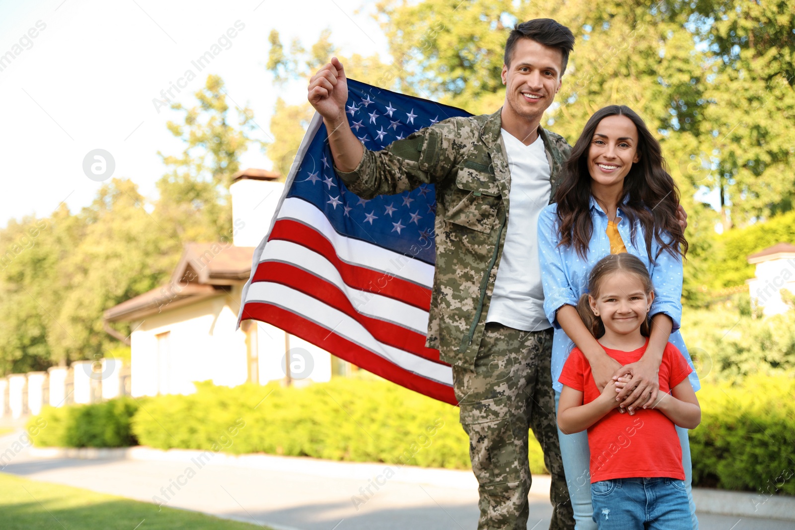 Photo of Man in military uniform and his family outdoors