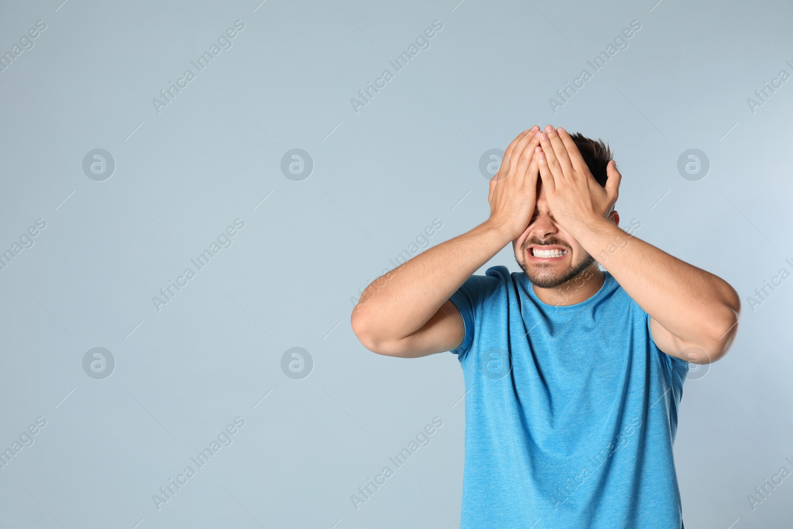 Photo of Young man being blinded on grey background, space for text