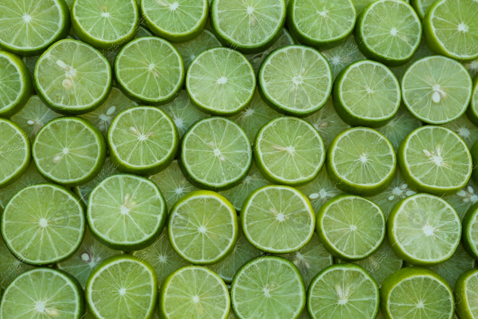 Photo of Fresh lime slices as background, top view