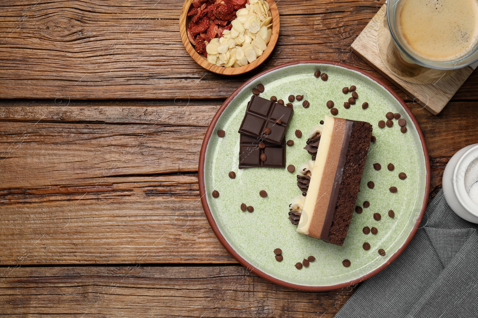 Photo of Tasty chocolate mousse cake and ingredients on wooden table, flat lay. Space for text