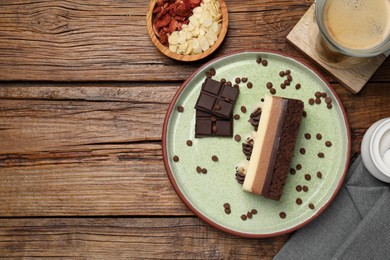 Photo of Tasty chocolate mousse cake and ingredients on wooden table, flat lay. Space for text
