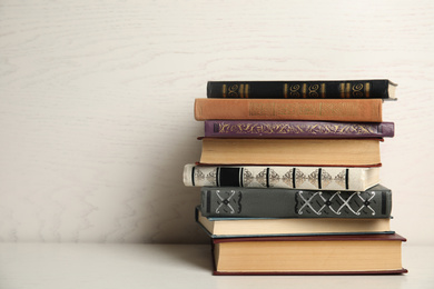 Photo of Collection of different books on table against white wooden background. Space for text