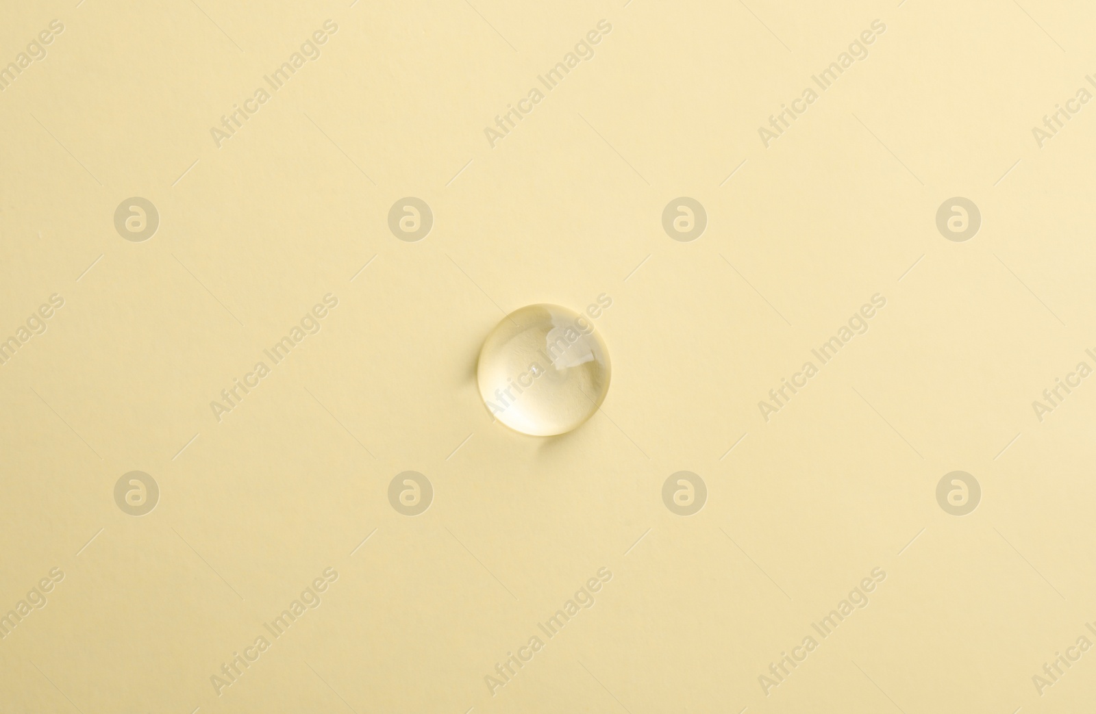 Photo of Drop of transparent ointment on beige background, top view