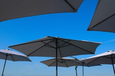 Photo of Beach umbrellas against blue sky on sunny day