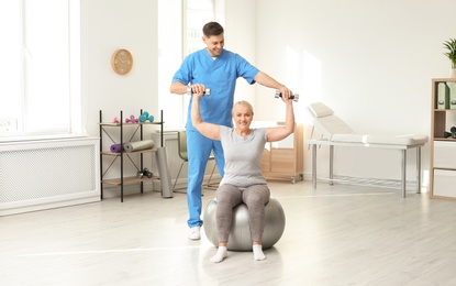 Photo of Physiotherapist working with patient in clinic. Rehabilitation therapy