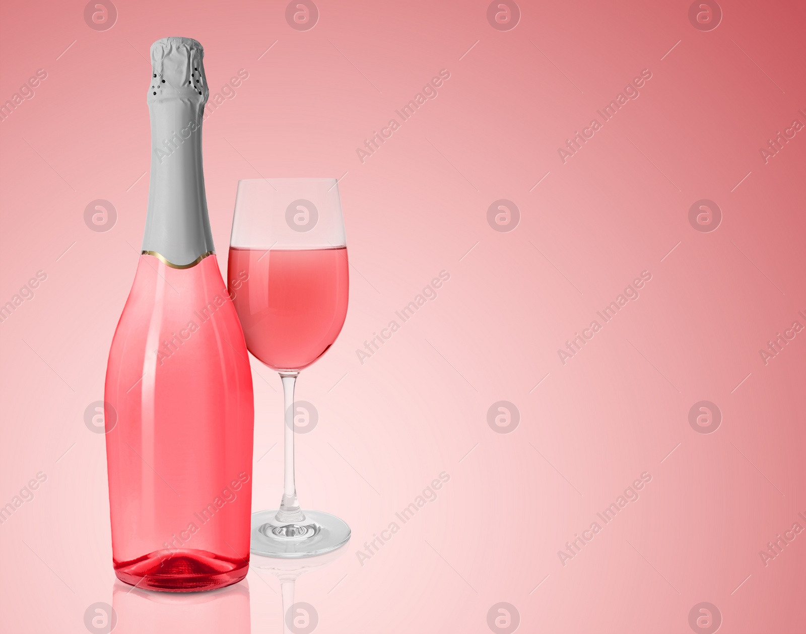 Image of Bottle and glass of delicious rose wine on pink background. Space for text