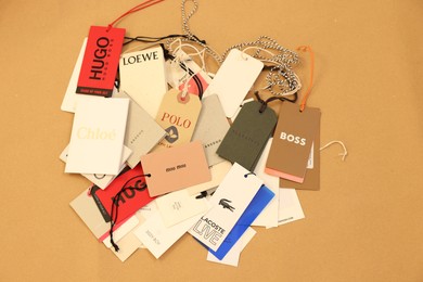 Leiden, Netherlands - December 6, 2023: Different clothing tags on kraft paper sheet, top view