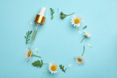 Photo of Flat lay composition with chamomile flowers and pipette of essential oil on color background. Space for text