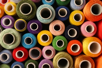 Photo of Set of color sewing threads as background, top view
