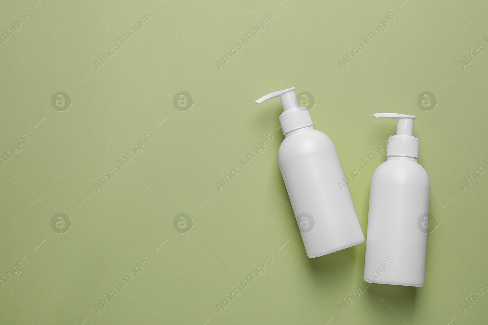 Photo of Different cleansers on olive background, flat lay with space for text. Cosmetic product