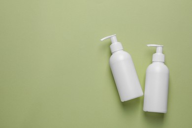 Photo of Different cleansers on olive background, flat lay with space for text. Cosmetic product