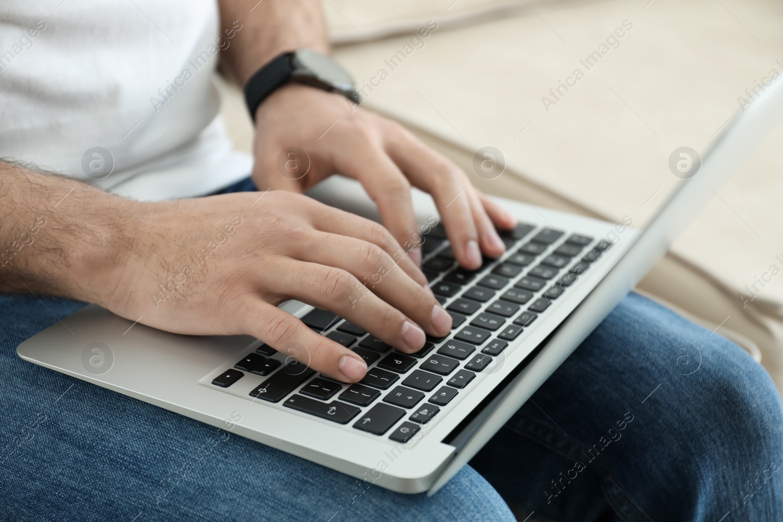 Photo of Man working on modern laptop at home, closeup