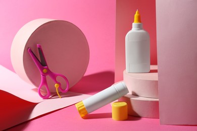 Photo of Composition with glue, paper and scissors on pink background