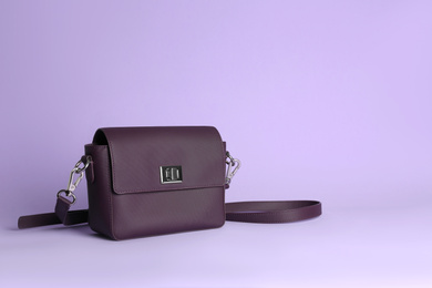 Photo of Stylish woman's bag on lilac background. Space for text