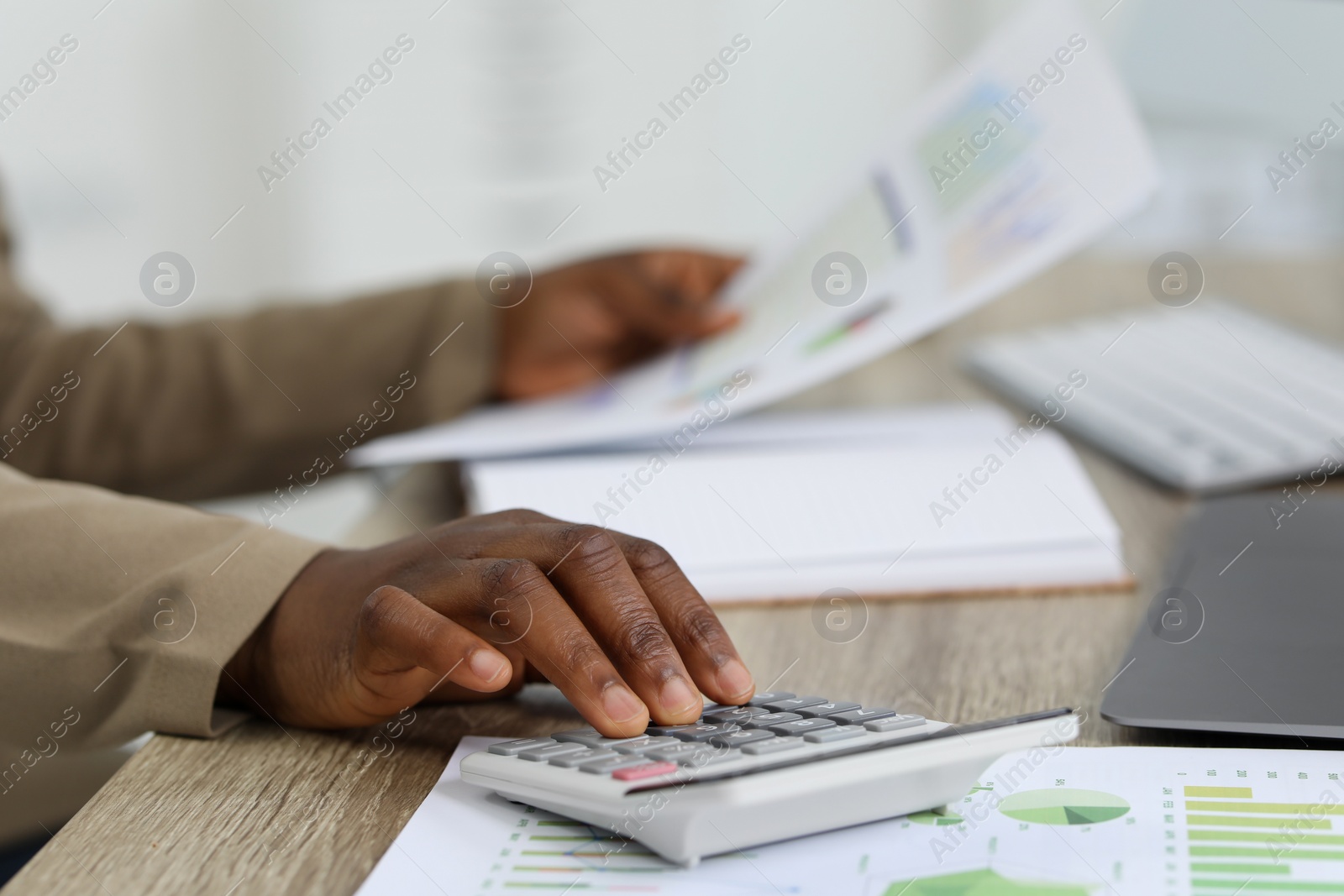 Photo of Professional accountant working at wooden desk in office, closeup