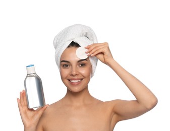 Young woman using cotton pad with micellar water on white background