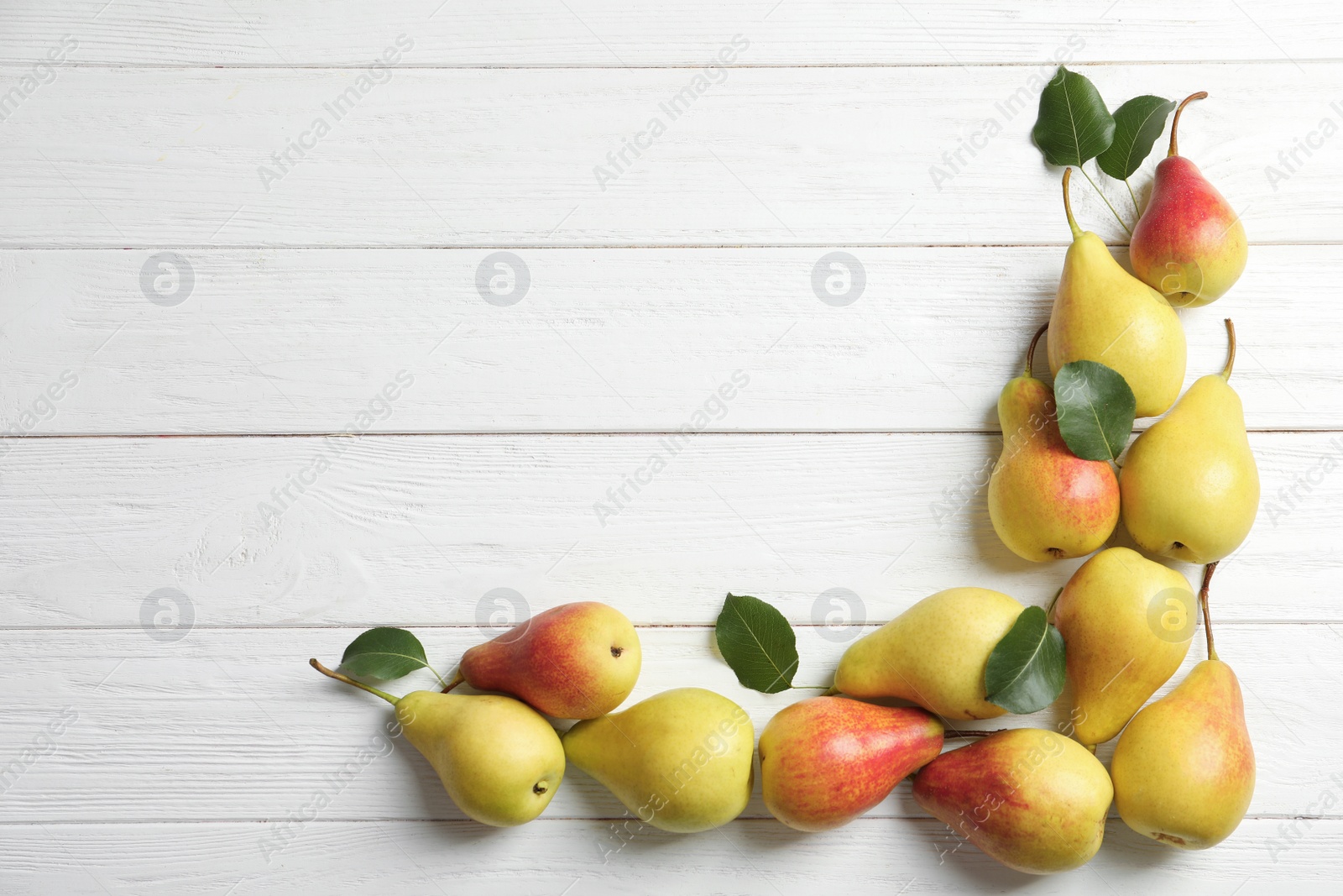 Photo of Flat lay composition with ripe pears on white wooden background. Space for text