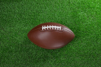 Photo of Leather American football ball on green grass