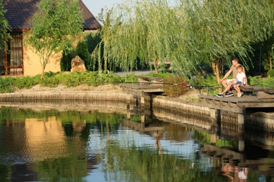 Photo of Dad and son fishing together on sunny day