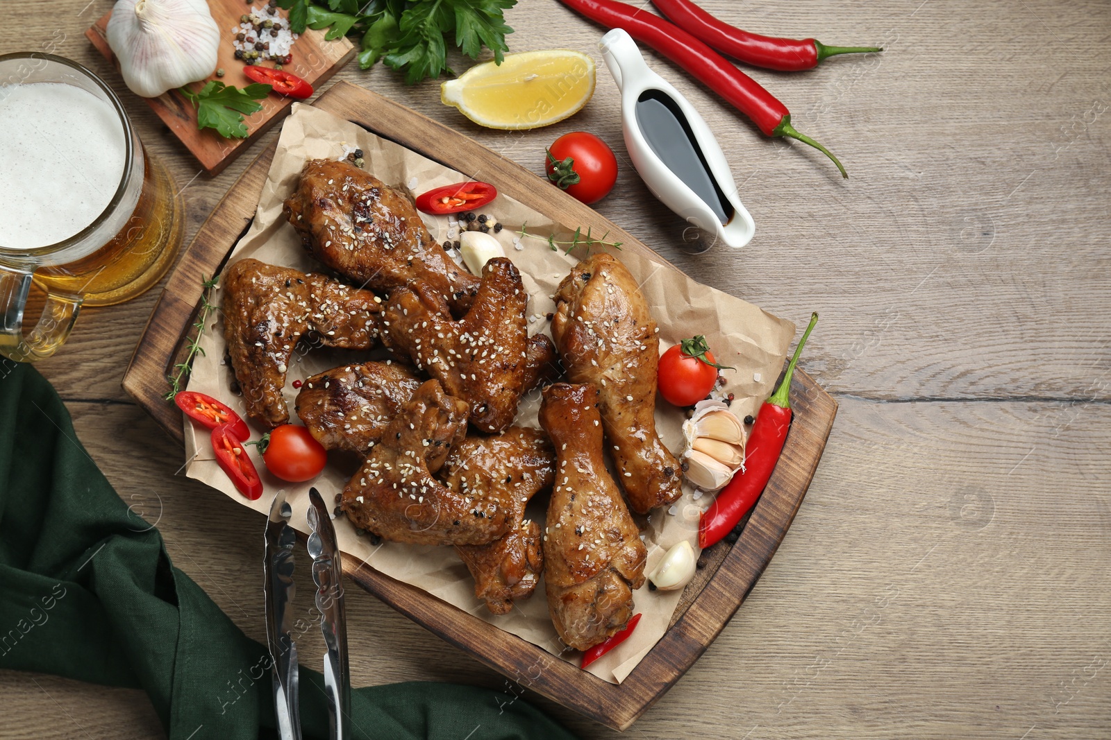 Photo of Tasty chicken glazed in soy sauce and different products on wooden table, flat lay. Space for text
