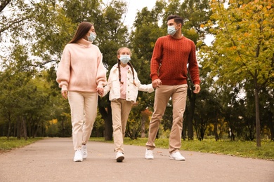 Lovely family walking together in park during coronavirus pandemic