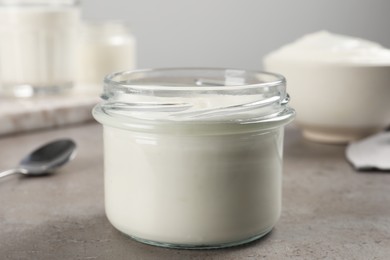 Jar with delicious organic yogurt on grey table, closeup