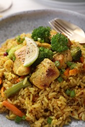 Tasty rice with meat and vegetables in plate, closeup