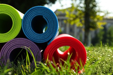 Bright exercise mats on fresh green grass outdoors, closeup