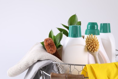 Photo of Set of different cleaning supplies in basket on white background