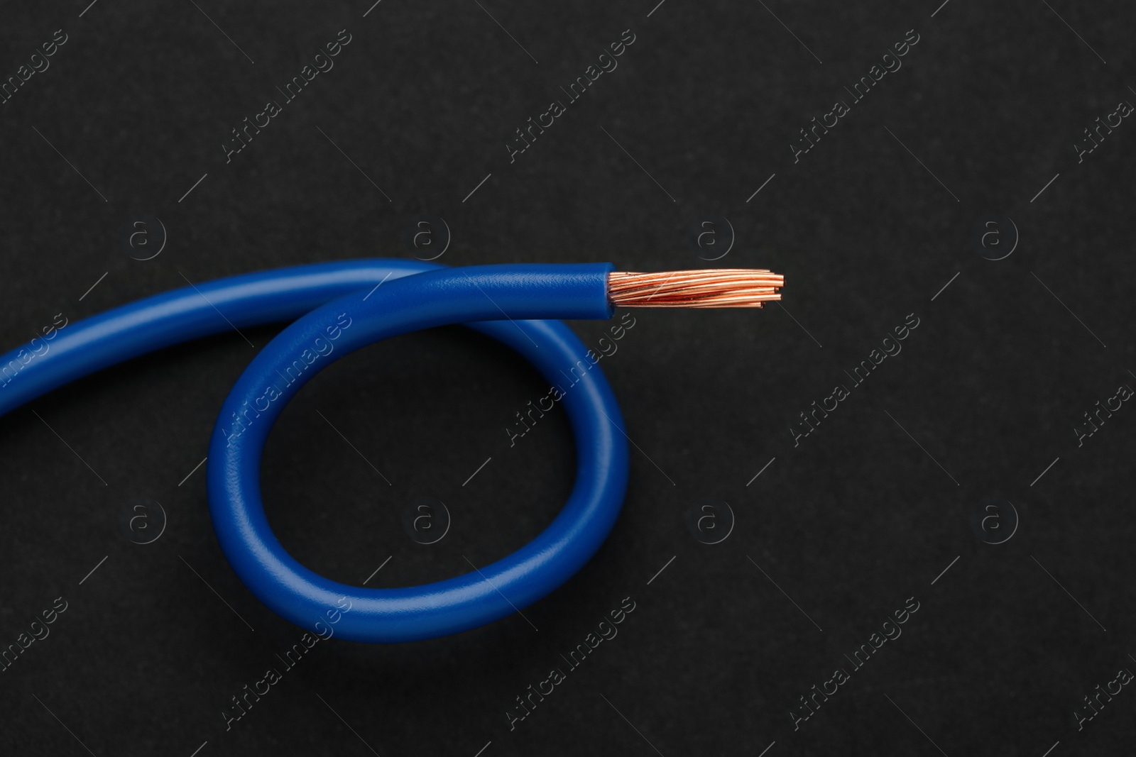 Photo of Blue electrical wire on black background, top view