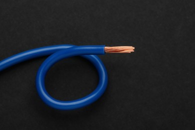 Photo of Blue electrical wire on black background, top view