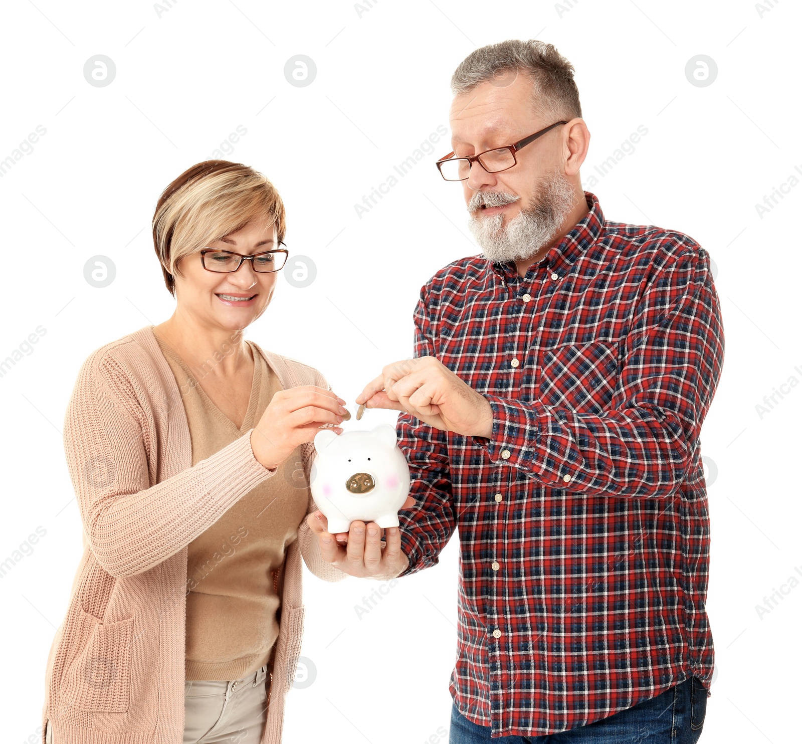 Photo of Happy senior couple putting coins into piggy bank on white background