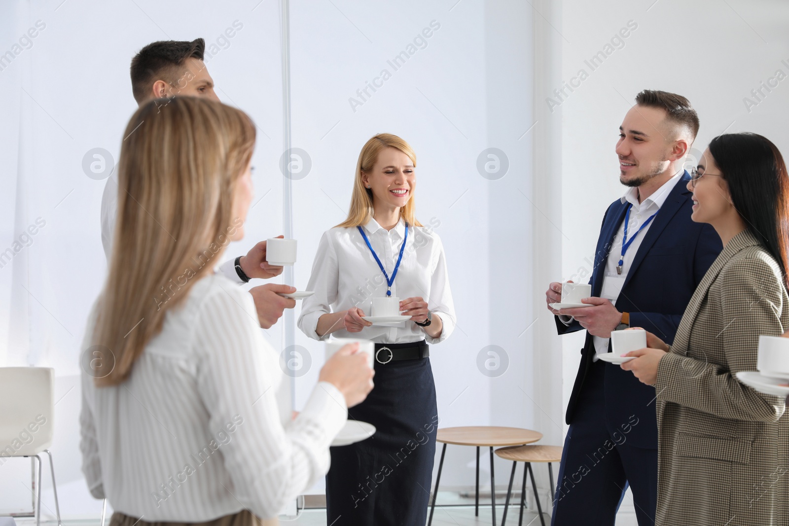 Photo of Group of people chatting during coffee break indoors