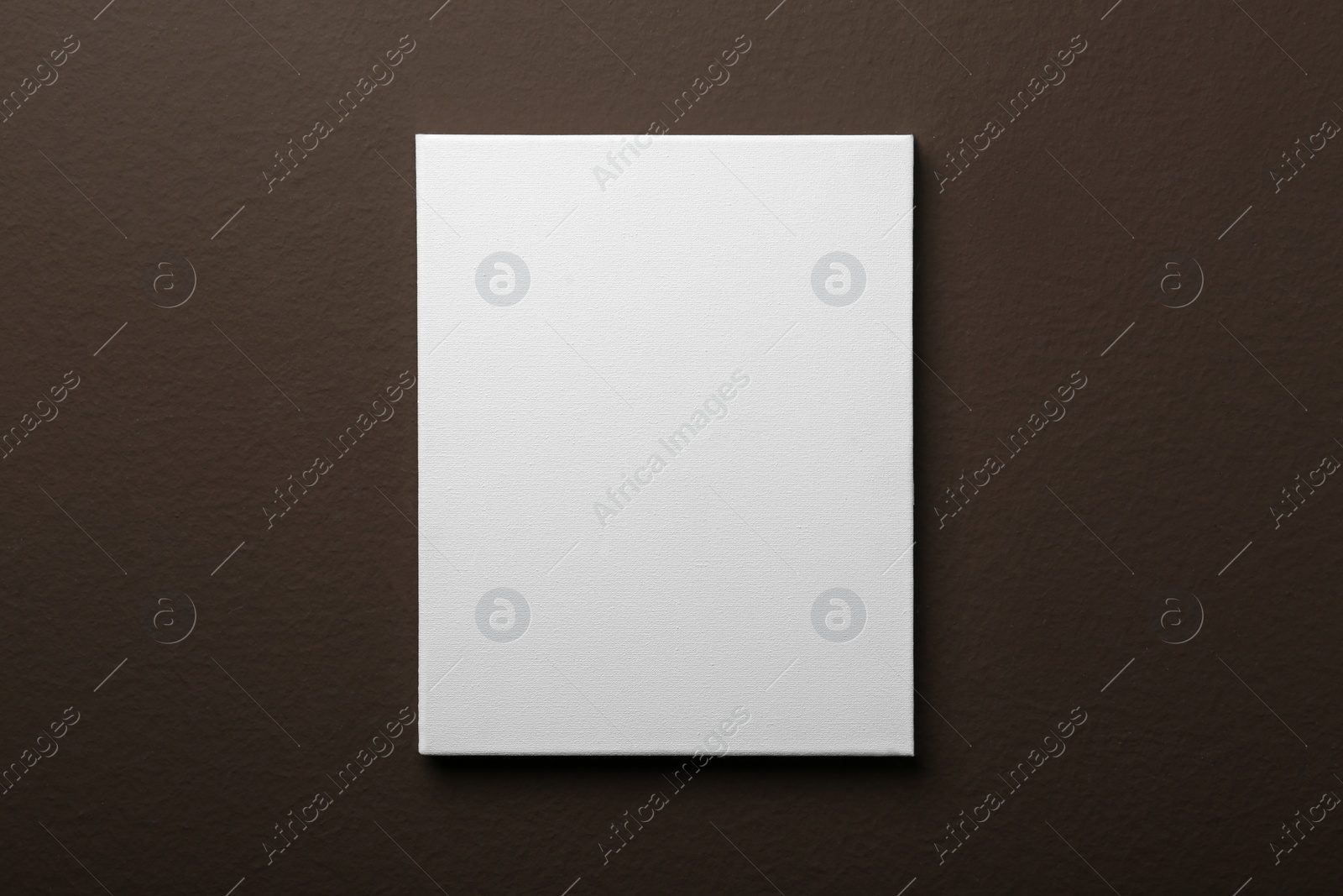 Photo of Blank canvas on brown wall. Space for design