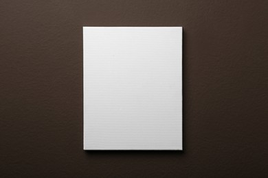 Photo of Blank canvas on brown wall. Space for design