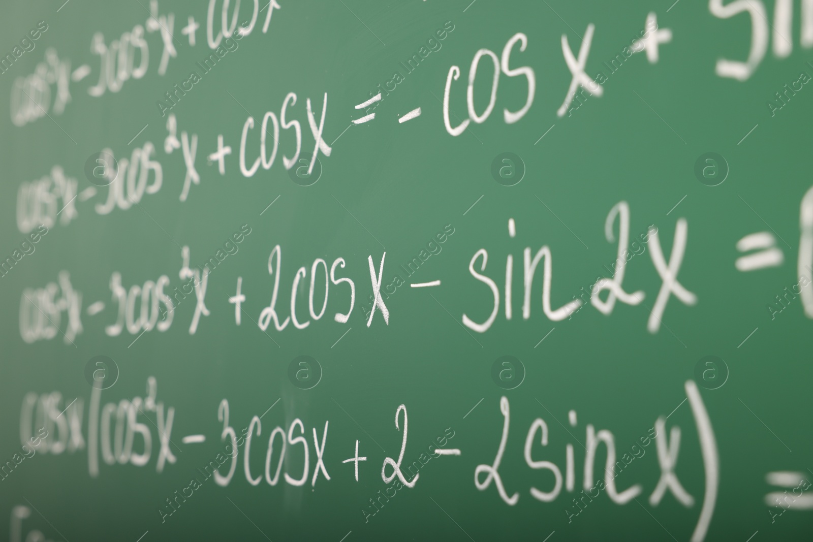 Photo of Many different math formulas written on green chalkboard, closeup